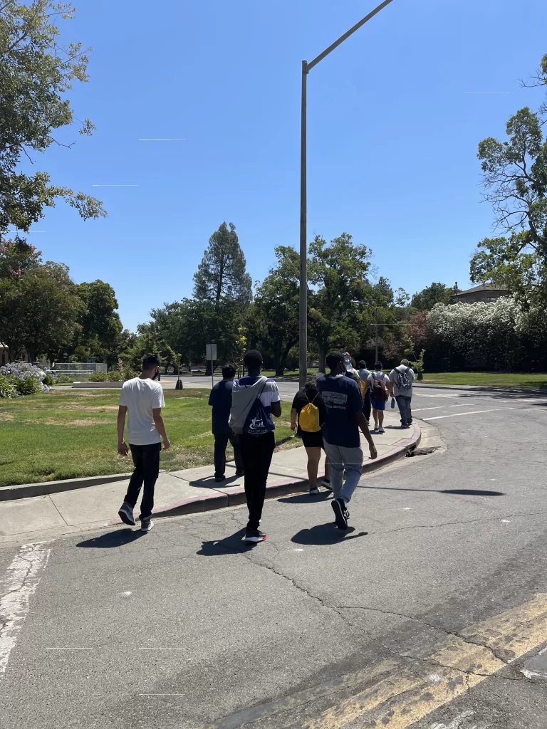 Students crossing across street at crosswalk by school