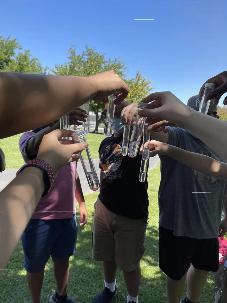 Students in circle showing results of chemistry experiment