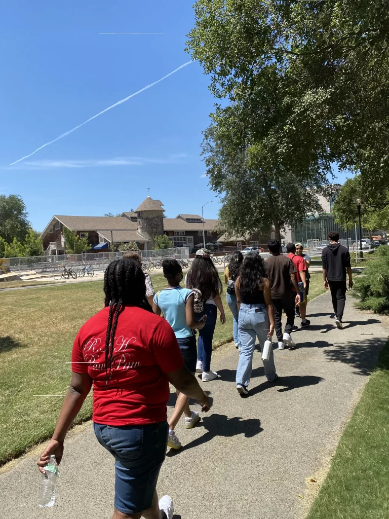 Students strolling down sidewalk towards school
